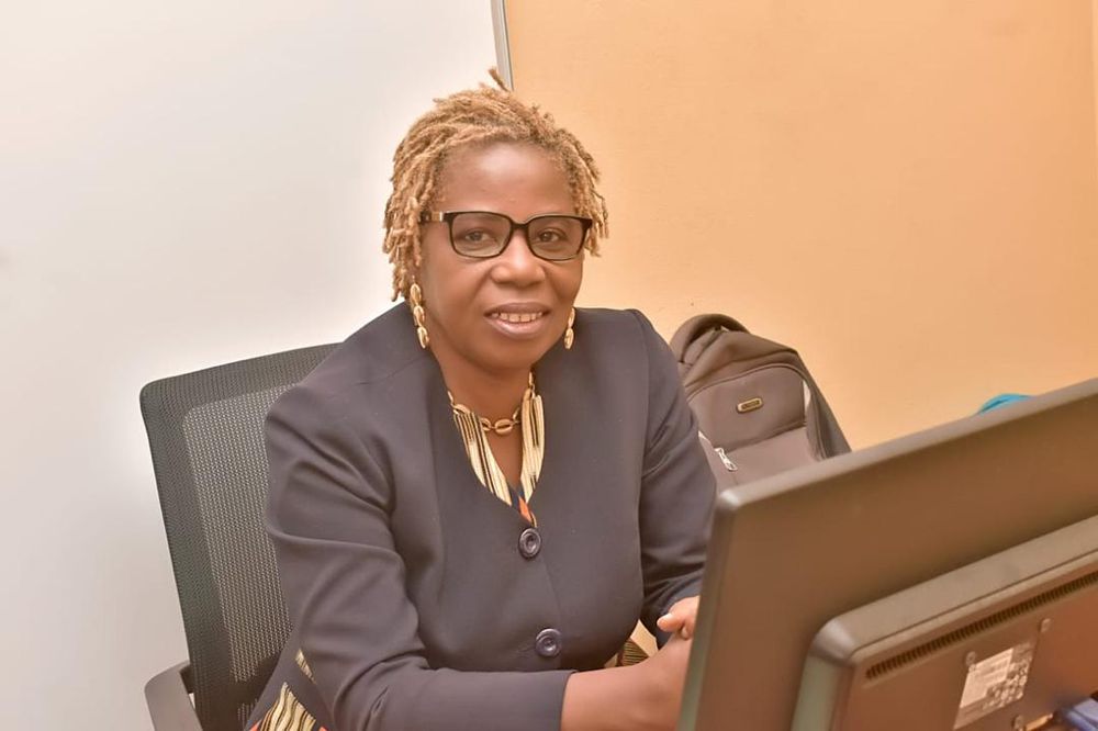 Portrait de la Présidente, assise à un bureau devant un ordinateur